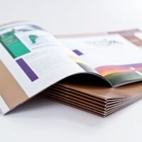 Ein aufgeblättertes Magazin, dass auf einem Stapel Magazinen liegt.