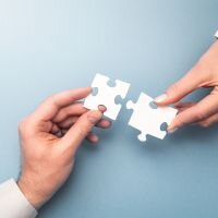 Zwei Puzzelteile die zueinander geführt werden.