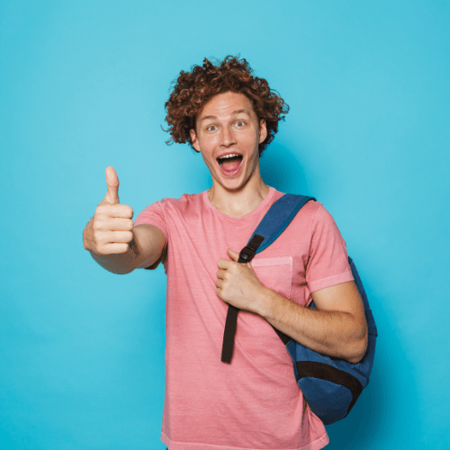 Ein Schüler mit einer Tasche vor einer blauen Wand.