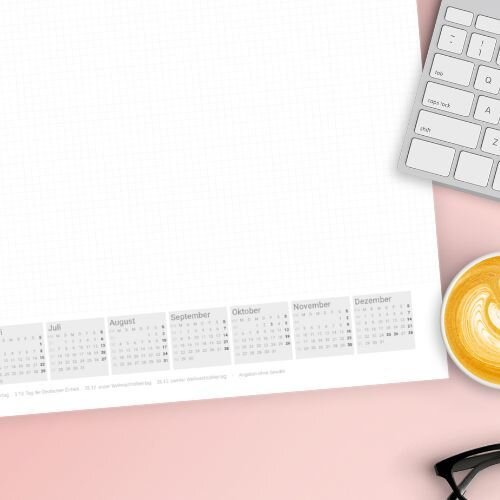 Eine Schreibtischunterlage von Rainbowprint auf einem rosa Tisch. Davor ist ein Laptop und ein Kaffee zu erkennen.