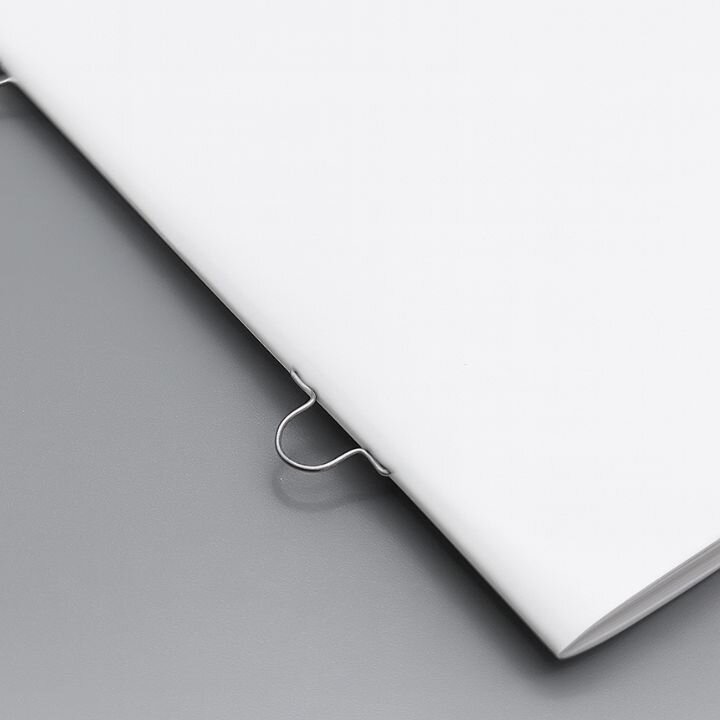 Eine Broschre mit Ringsenheftung, die auf einem grauen Tisch liegt.