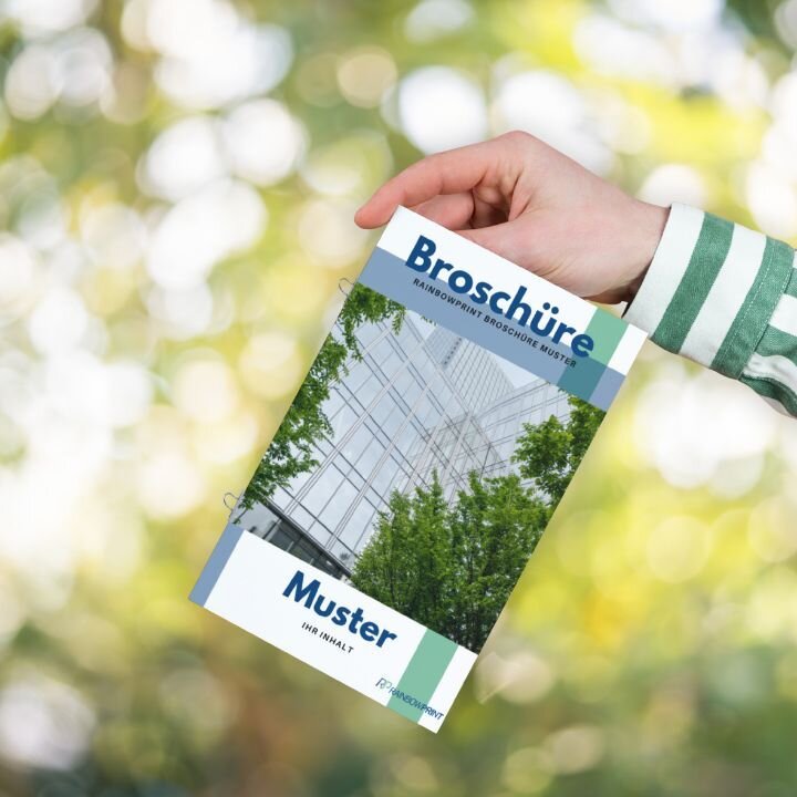 Eine Broschre mit Ringsenheftung, die von einer Person in der Hand gehalten wird.