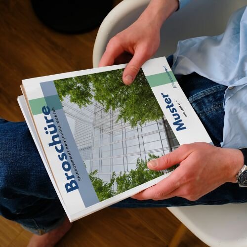 Ein Magazin von Rainbowprint im DIN Format. Es wird leicht geöffnet in den Händen gehalten.