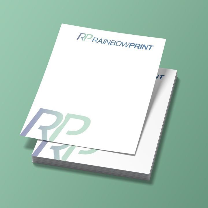 Ein Stapel Flyer von Rainbowprint GmbH auf t�rkisem Hintergrund.