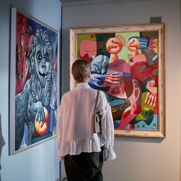 Eine Galerie mit verschiedenen Kunstwerken, die betrachtet werden.