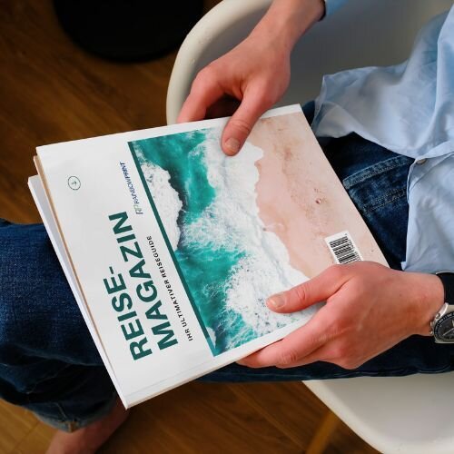 Ein Magazin für Tourismus, Reisen und Freizeit von Rainbowprint, welches von einer Person in der Hand gehalten wird.