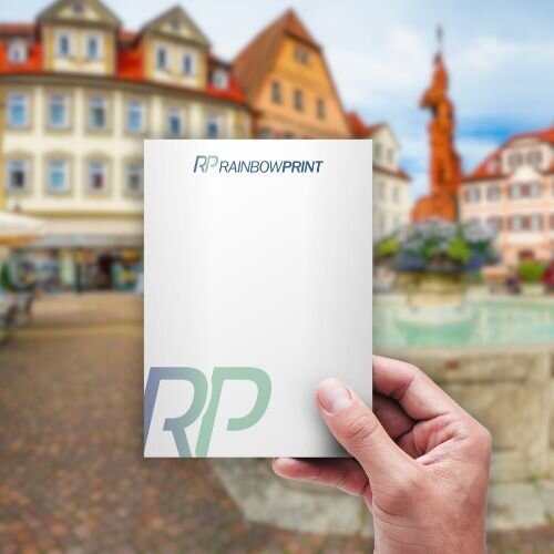 Ein Flyer von Rainbowprint. Im Hintergrund ist eine deutsche Altstadt zu sehen.